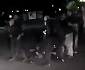 Flash as cop leaning forward shoots Enoch Gaver in the back